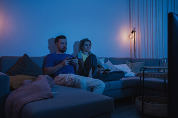 Couple Playing Video Games Together in Cozy Living Room at Night