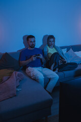 Couple Playing Video Games Together in Cozy Living Room at Night