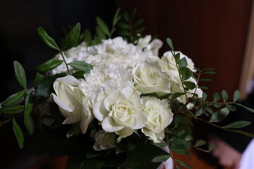 A beautiful bouquet of white roses with green periwinkle.