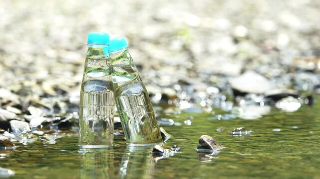 Two glass bottles of ramune soda in a cool river, Beverage or drink, Nobody