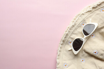 Sunglasses on a plain background. Summer, chamomile
