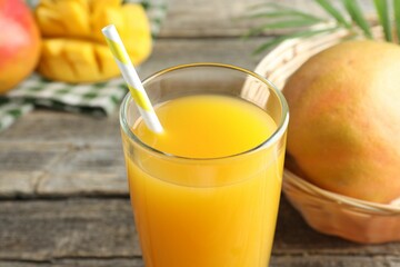 Tasty mango juice in glass and fresh fruits on table, closeup