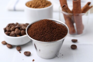 Instant coffee powder, beans and cinnamon sticks on light table, closeup