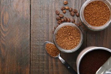 Instant coffee in jars and beans on wooden table, flat lay. Space for text
