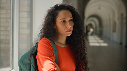Sad frustrated lonely upset stressed depressed pensive thinking Hispanic woman Latina girl student female in university college academy corridor learning studying problem education failure bullying