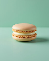 Single Beige Macaron with Cream Filling on Mint Green Background for Bakery and Dessert Concepts