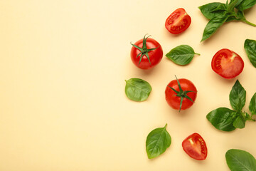 Cherry tomatoes and green basil on beige background
