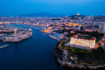 Fototapeta premium Aerial view of old port, Tour du Fanal and Basilica of Notre Dame at Marseille, France at night