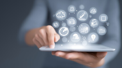 Person interacts with digital tablet, engaging with floating icons representing various digital learning concepts. image conveys sense of modern technology and innovation