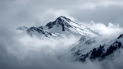 Snow Capped Mountain Peak Emerging From Foggy Clouds .