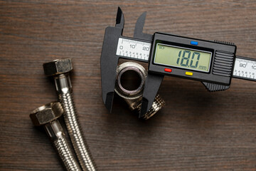 Measuring the diameter of plumbing adapters with an electronic digital caliper, closeup, top view....