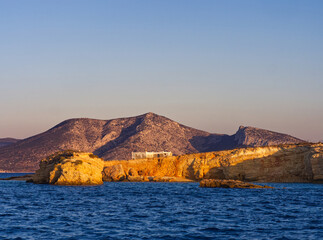 Scenic view of golden cliffs and rugged mountains overlooking deep blue sea at dusk. Koufonisia Islands, Cyclades, Greece