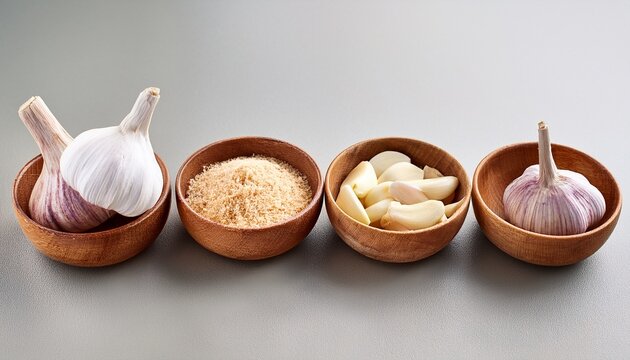 quatre bols en bois contenant differentes formes d ail bulbes entiers gousses pelees et morceaux haches