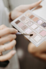 Make-up artist at work. Make-up artist tools: brush and palette for make-up in the hands of a...