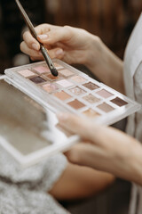 Make-up artist at work. Make-up artist tools: brush and palette for make-up in the hands of a...