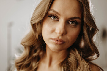 Portrait of attractive young woman with wavy hair. Model looks expressively at camera. Close-up