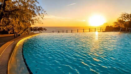 Water reflects the warm yellow sunset sky beside a peaceful swimming pool, evoking a calm vacation atmosphere, perfect for relaxation, unwinding, and enjoying tranquil moments in a serene environment.