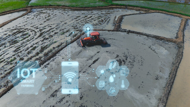 A tractor in a flooded farmland field uses IoT smart farming technology with mobile and sensor data icons overlayed for precision agriculture.