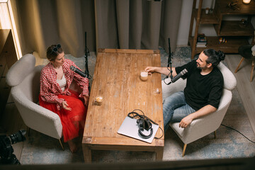 Video podcast recording studio. A conversation between a man and a woman sitting in front of...