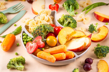 Baby finger food, various baby snacks, pasta, vegetables, fruits chopped for convenient, safe children's lunch, teaching small child to eat healthy food
