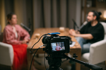 Video podcast recording studio. A conversation between a man and a woman sitting in front of...