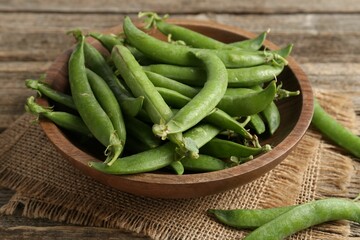 Fresh ripe green peas on wooden table, closeup