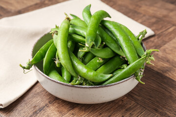 Fresh ripe green peas on wooden table, closeup