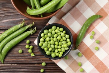 Fresh ripe green peas on wooden table, flat lay