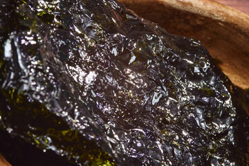 Nori chips laid out in a wooden bowl emphasizing texture and color in a cozy kitchen setting