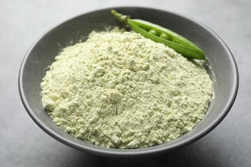 Protein powder and green peas on grey table, closeup