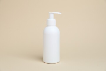 One white bottle of cosmetic product on beige background