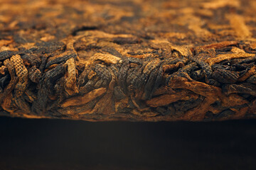 Close-up view of a puer tea cake reveals its intricate texture and rich color.