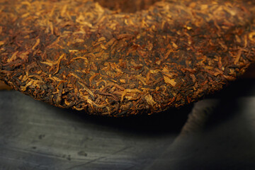 Close-up view of a puer tea cake reveals its intricate texture and rich color.