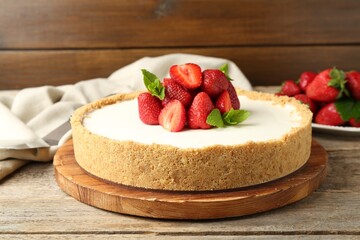 Tasty cheesecake with strawberries and mint on wooden table, closeup