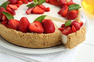 Delicious cheesecake with strawberries and mint on white table, closeup