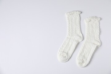 Pair of comfortable socks on white background, top view. Space for text