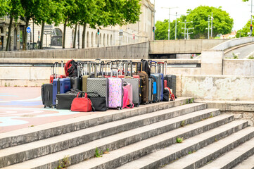 A large number of suitcases and bags are standing in the open air, in the city, on the edge of the...