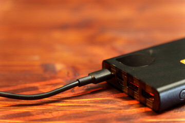 Charging device connects to a power bank for portable energy supply during travel or outdoor activities