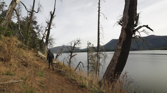 Man in trail of Huella Andina in &Ntilde;orquinco lake on a cloudy day of autumn season. Lanin National Park, Neuquen, Argentina