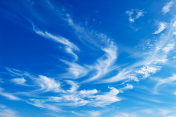 Ethereal wispy cirrus clouds creating delicate white streaks across a vibrant azure blue sky,...