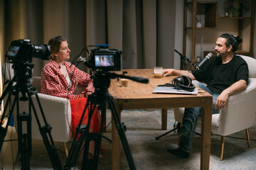 Video podcast recording studio. A conversation between a man and a woman sitting in front of...