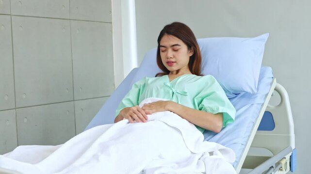 Weak female patient with abdominal pain and inflammatory bowel disease lies on a patient bed, looking and waiting for the doctor and nurse to come and see her.