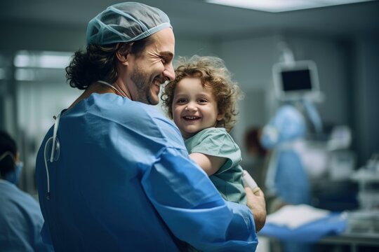 Surgeon holding and comforting smiling child before surgery in hospital operating room
