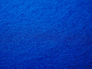 Close up of a textured blue fabric with a subtle weave and soft focus background
