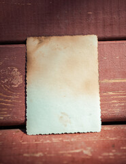 Vintage empty paper lies on the old wooden texture of bench