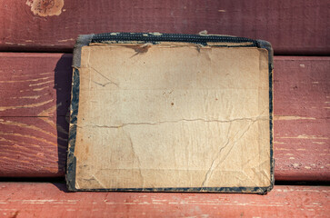 Vintage empty paper lies on the old wooden texture of bench