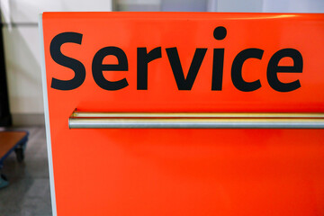Bright orange service desk in an airport terminal, designed to assist travelers and provide...
