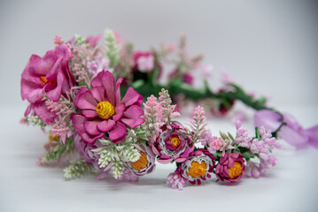 Handmade floral headband made of pink eva foam, pastic branches and stamens. Summer hair accessory for a girl, close up.