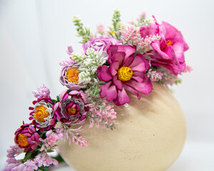Handmade floral headband. Flowers made of pink eva foam, pastic branches and stamens, displayed on ostrich egg, side view. Summer hair accessory for a girl.