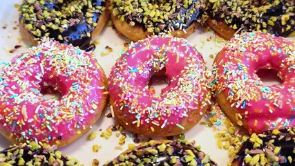 Assorted colorful donuts with sprinkles. Freshly baked glazed donuts with filling.  - Powered by Adobe